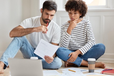 couple sitting in the floor going over paperwork